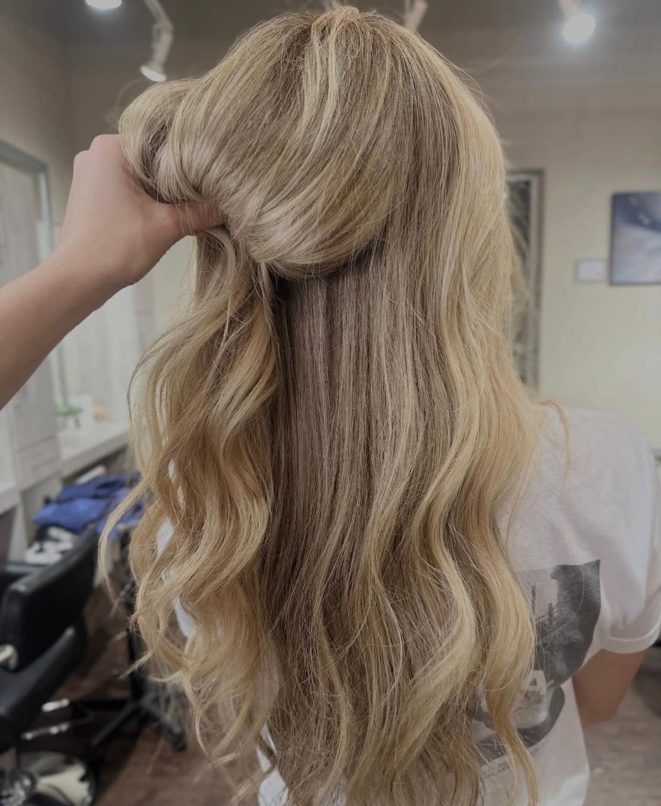 Long blonde hand-tied hair extensions styled at Lee Graves Salon in Plano, TX